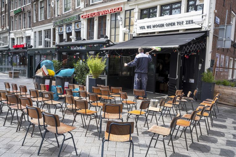 Een horecaondernemer maakt een terras aan het Leidseplein schoon. Nu de coronamaatregelen versoepeld zijn, is op een terras zitten weer mogelijk. Beeld 