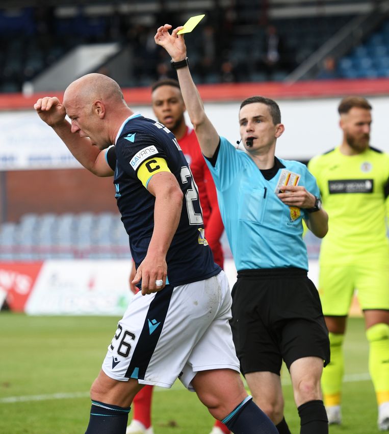 Scheidsrechter Craig Napier geeft een gele kaart aan een speler van Dundee in een wedstrijd uit de Schotse Premiership. Beeld SNS Group via Getty Images