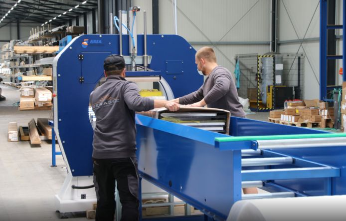Medewerkers van Verasol bij een machine voor het verpakken van veranda's, aan het einde van een nieuwe productielijn die in de Duitse fabriek is geïnstalleerd.