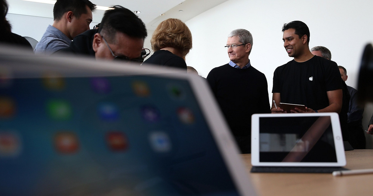Apple-CEO Tim Cookkijkt naar de display van een nieuw 9.7 iPad-model . Beeld afp