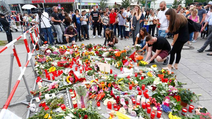 Mensen leggen bloemen bij het winkelcentrum in München waar de schietpartij plaatsvond.