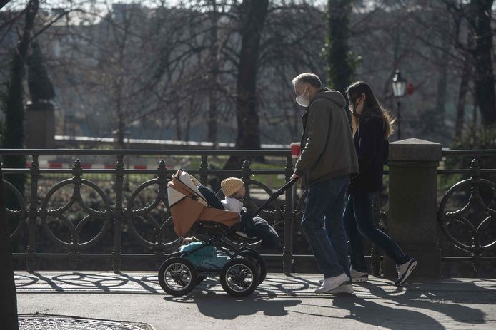 Een familie op  wandel in een park in Praag. Ook het kindje in de kinderwagen zal vanaf morgen een mondkapje moeten dragen.