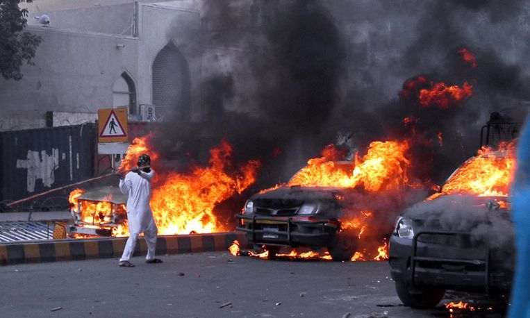 Brandende auto's in Karachi, Pakistan bij protesten tegen de video. Beeld EPA