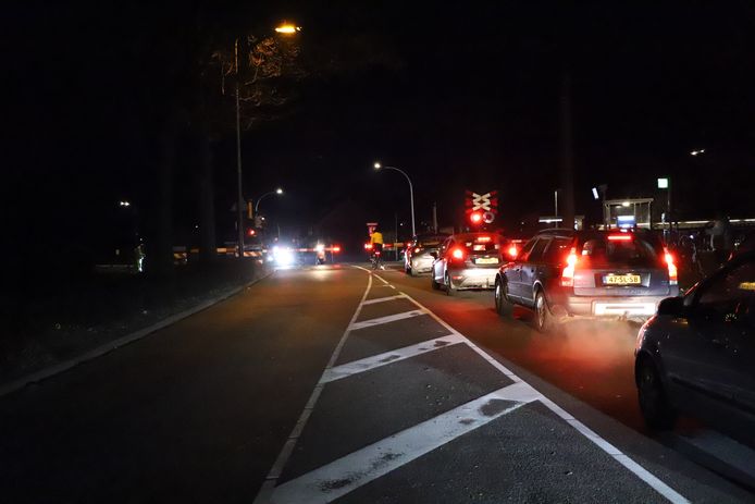 Auto's staan te wachten voor de spoorwegovergang.