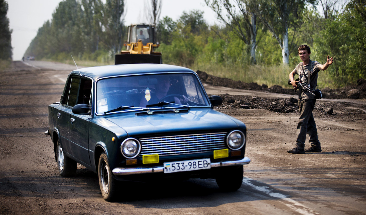 Een separatist houdt de wacht bij een checkpoint op de weg tussen Donetsk en het rampgebied van de MH17. Beeld anp