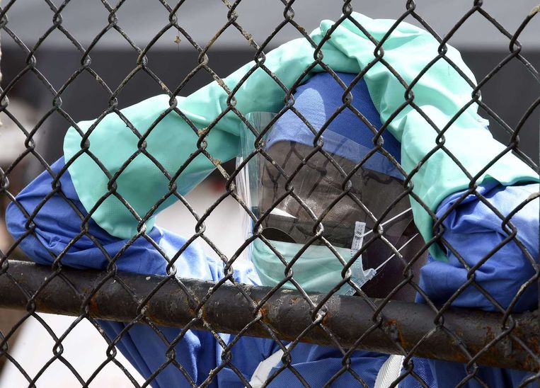 Een medewerker bewaakt de poort van een hospitaal waar ebolapatiënten worden behandeld. Beeld afp