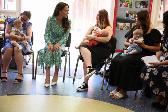 Princess Kate with the child taking her hand on the left and the baby burping on the right.