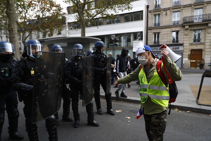 Een demonstrant met een geel hesje staat oog in oog met de politie tijdens de demonstratie in Parijs. (28/08/2021)