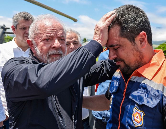 De Braziliaanse president Luiz Inacio Lula da Silva (L) troost een reddingswerker in Sao Sebastiao.