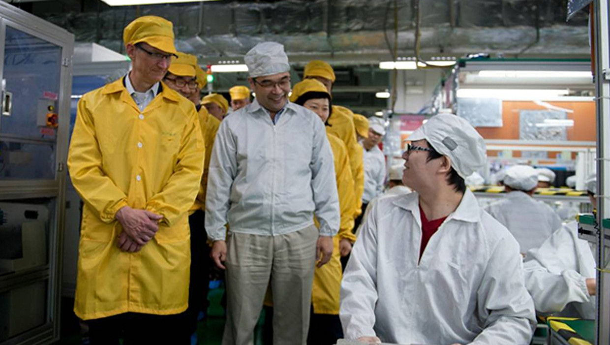 Apple-baas Tim Cook (links) aan de lopende band voor iPhones in het Foxconn Zhengzhou Technology Park in Zhengzhou. Beeld AFP
