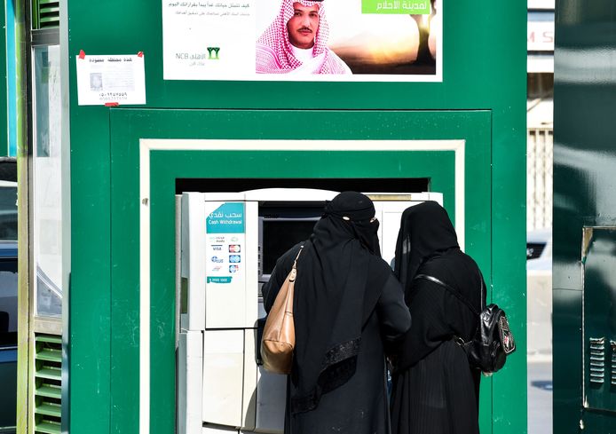 Tweee vrouwen pinnen in Saoedi-Arabië. Voor de meeste activiteiten in het land hebben zij toestemming van een mannelijke voogd nodig.