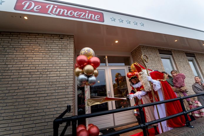 Met het doorknippen van een goudkleurig lint opent Sinterklaas op zijn verjaardag de nieuwe kinderopvanglocatie De Limoezine in Bergen op Zoom, een dependance van Le Garage, een paar honderd meter verderop.