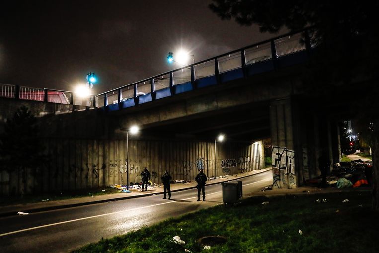 in Ivry Sur Seine, nabij Parijs, wachten Franse agenten op de komst van bussen waarmee migranten worden geëvacueerd die er op straat leven. Beeld ANP / EPA