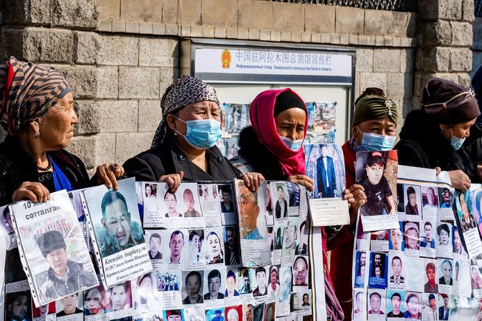 Gevluchte Oeigoeren houden aan het Chinese consulaat in de Kazachse grootstad Almaty foto's vast van gedetineerde familieleden.