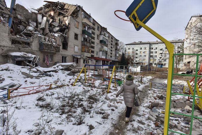 Een Oekraïense vrouw loopt langs een gebombardeerd gebouw in de plaats Sviatohirsk, in de regio Donetsk.