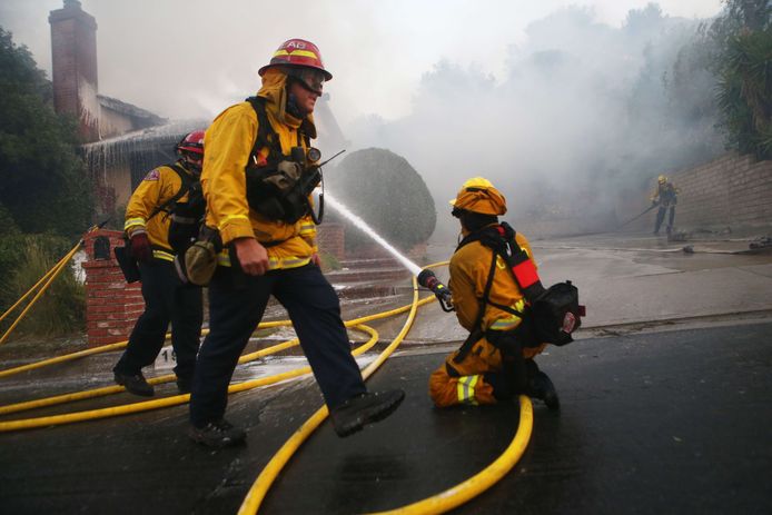 PORTER RANCH, CALIFORNIA - OCTOBER 11: Firefighters work at a house fire after dawn during the Saddleridge Fire on October 11, 2019 in Porter Ranch, California. The fast moving wind-driven fire has burned more than 7,500 acres and destroyed 25 structures.   Mario Tama/Getty Images/AFP
== FOR NEWSPAPERS, INTERNET, TELCOS & TELEVISION USE ONLY ==