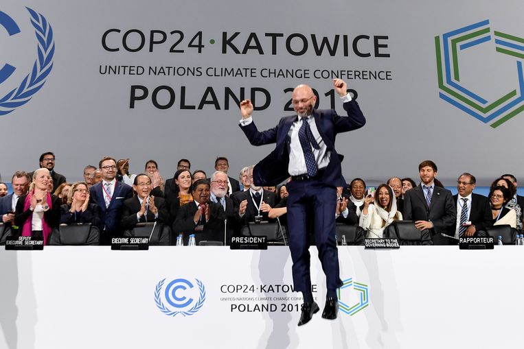 ► Michal Kurtyka, de voorzitter van de top, springt van tafel na afloop van de klimaattop in Katowice in Polen. Beeld AFP