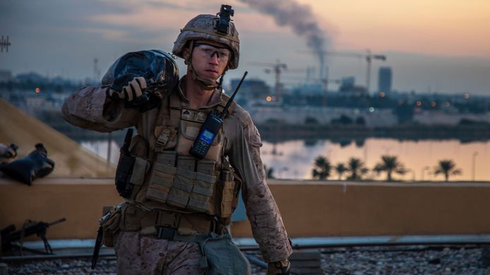 Een Amerikaanse marinier voert zandzakken aan om de Amerikaanse ambassade in Bagdad te versterken.