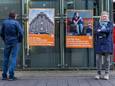 De dakloze ‘Martin’ (links) voor de campagneposters in Den Haag die oproepen om de vele lege panden in de stad te gebruiken voor daklozen. Directeur Marlies Filbri van Straat Consulaat: ,,We kunnen het probleem nu oplossen.’’