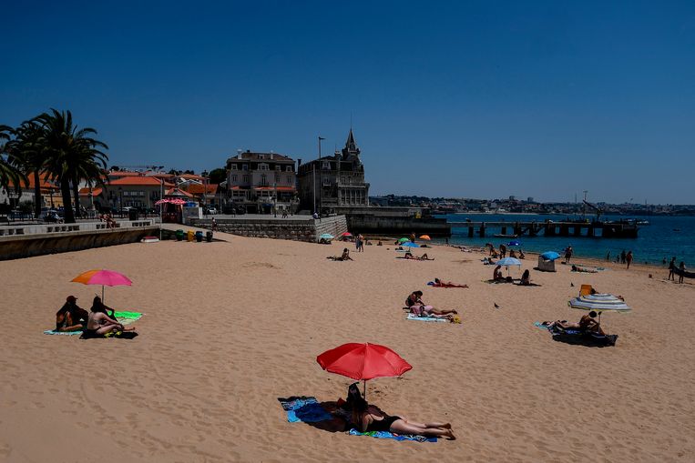 Mensen aan het zonnebaden in Lissabon, Portugal. Beeld AFP