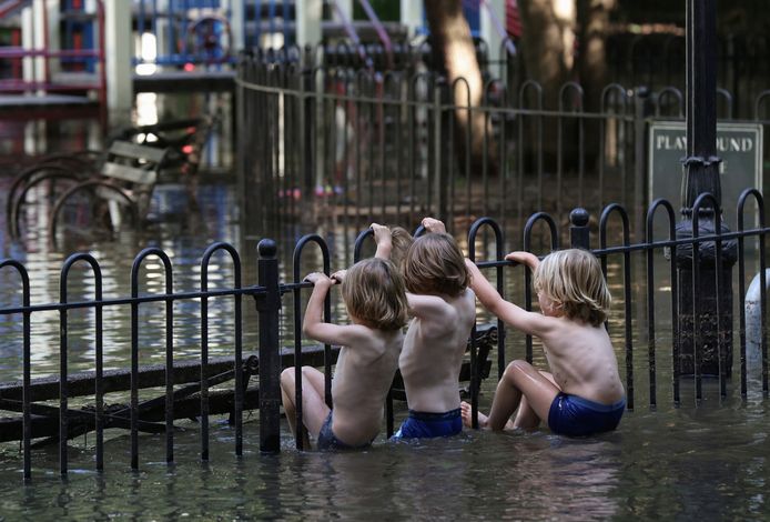 Kinderen klimmen op een hekje in New York, na de doortocht van storm Ida eind augustus en begin september in New York, die hevige overstromingen veroorzaakte in de stad en staat.