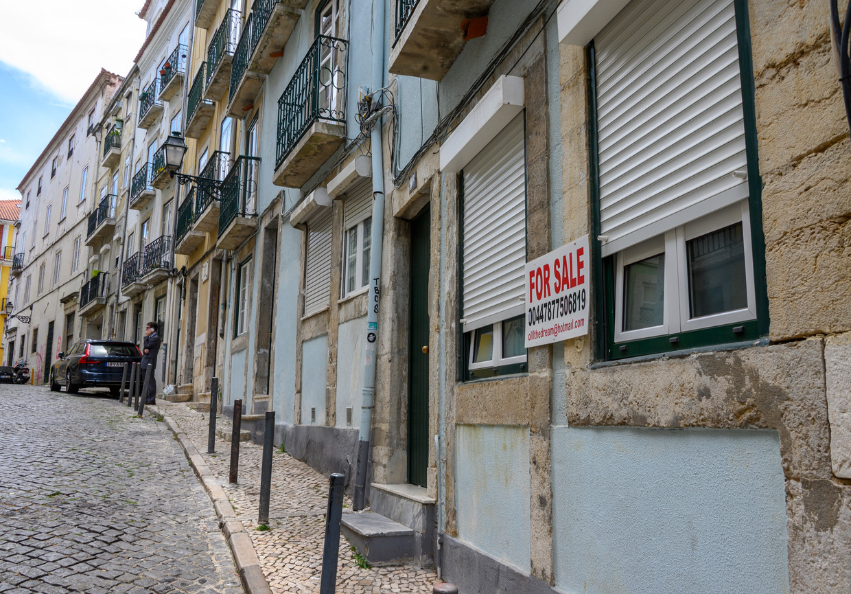 Een uithangbord voor de verkoop van een woning in een historische wijk in Lissabon in juli 2019. Beeld Corbis via Getty Images