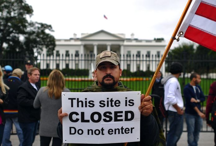 Een betoger toont een bord voor het Witte Huis in Washington.