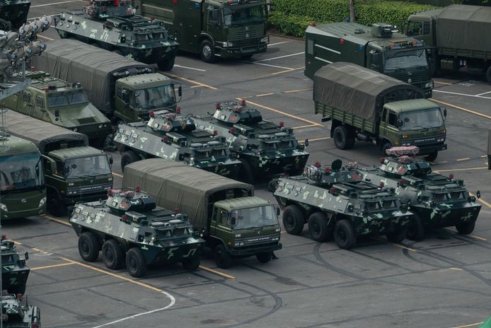 In het sportstadion van Shenzhen, een Chinese stad vlak bij Hongkong, staan de pantservoertuigen al opgesteld.