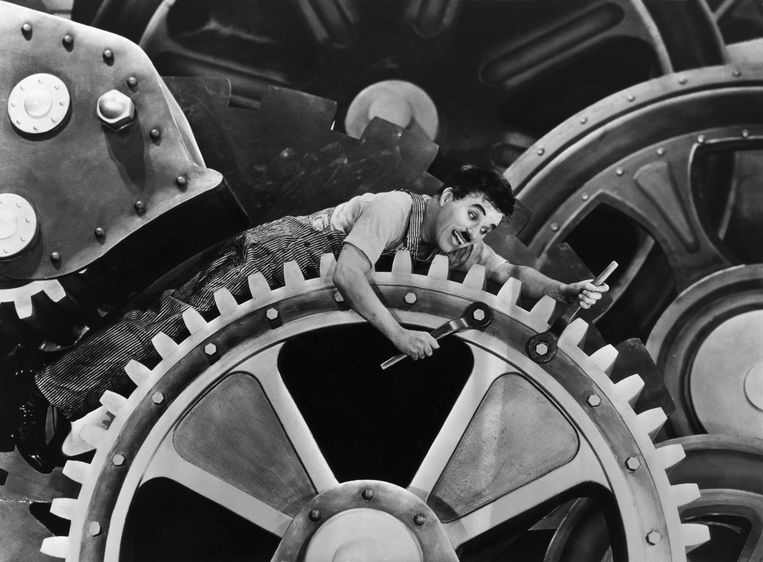 Charlie Chaplin als noeste arbeider in 'Modern Times' uit 1936. Beeld Bettmann Archive