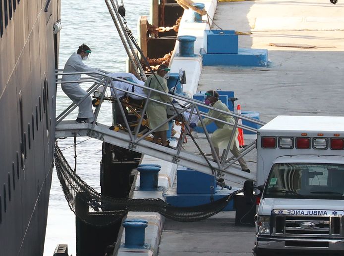 Een patiënt wordt door ambulancepersoneel van boord van de Zaandam gehaald in de haven Port Everglades in Fort Lauderdale, Florida.