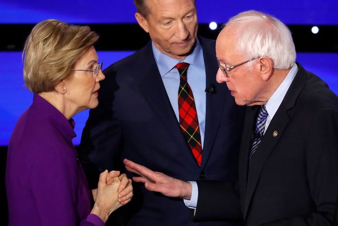 Elizabeth Warren tegenover Bernie Sanders (rechts) na afloop van het laatste debat. Medekandidaat Tom Steyer kijkt toe.