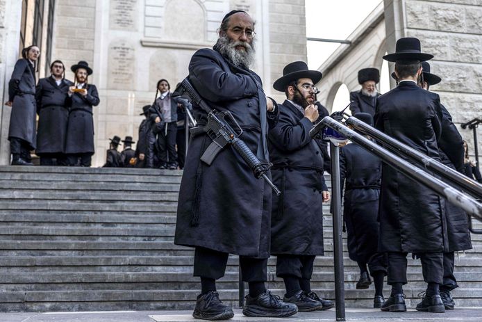 Een zwaar bewapende orthodoxe jood houdt de wacht voor een synagoge terwijl er een trouwfeest plaatsvindt, op 27 december in Jeruzalem.