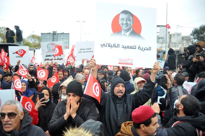 Tunesische betogers houden borden en nationale vlaggen omhoog tijdens een demonstratie tegen hun president, niet ver van het hoofdkwartier van de Tunesische Assemblee (parlement), in de hoofdstad Tunis.