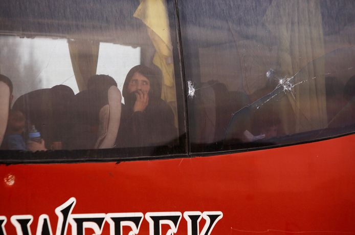Syrische rebellen en hun families verlaten per bus een tentenkamp in Douma.