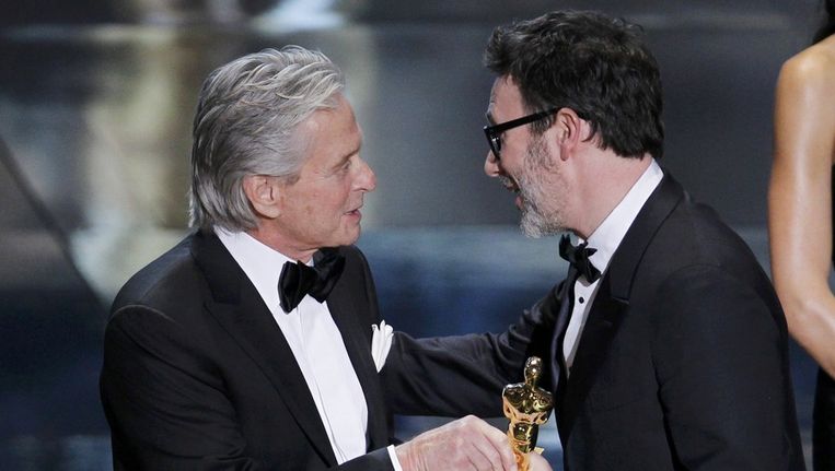 Michael Douglas overhandigt de Franse regisseur Michel Hazanavicius de Oscar voor de beste regie. Beeld reuters