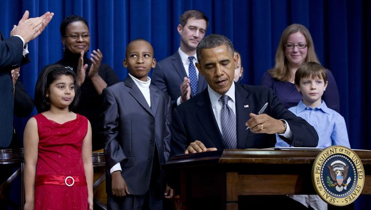 Obama tekent zijn voorstellen in aanwezigheid van kinderen die hem schreven over wapenbezit in de Verenigde Staten. Beeld ap