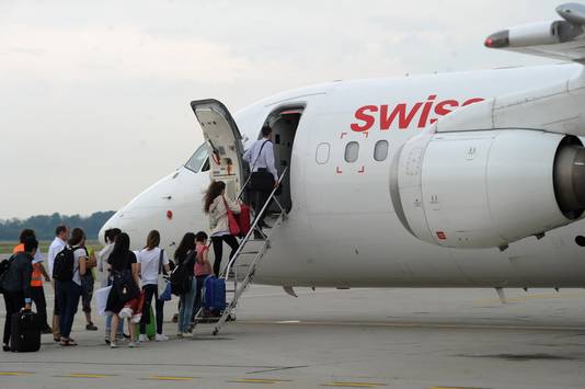 Passagiers gaan aan boord van een vliegtuig van Swiss International Air Lines in Milaan.