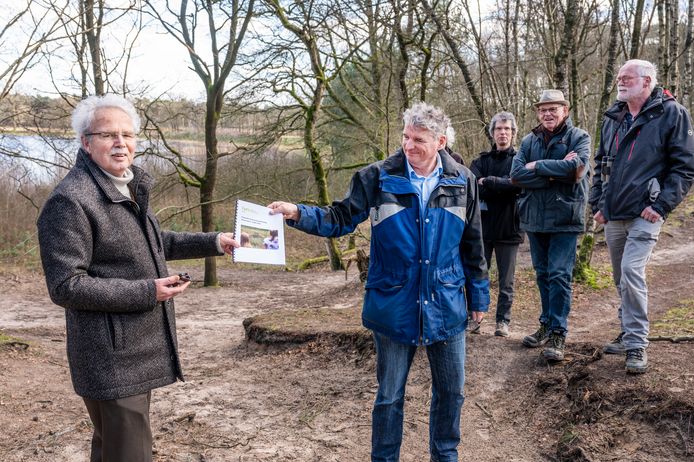 Geert Versteijlen (links) overhandigt het rapport over Herperduin aan waterschapsman Ernest de Groot. Op de achtergrond het Ganzenven dat nu vol staat maar in de drie recente warme zomers helemaal droog viel.