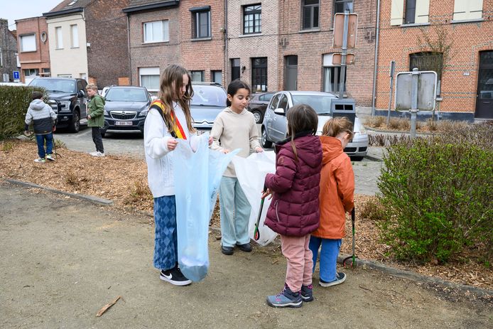 Kinderburgemeester Stien Booten (met sjerp) en kindergemeenteraadslid Ruquaya (midden) helpen de kinderen van Villa Kakelbont met het opruimen van het zwerfvuil.