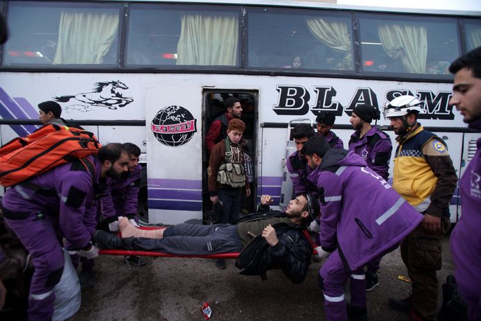 Vrijwilligers van de Violet Organization dragen een gewonde man. In totaal zouden 27 bussen de eerste lichting rebellenstrijders en hun families overbrengen van Oost-Ghouta naar Idlib, zo meldt Reuters.