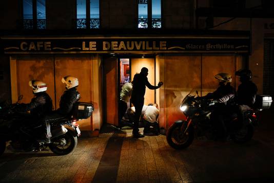 Werknemers van een restaurant in Parijs bevestigen houten platen voor de ramen van hun zaak. 