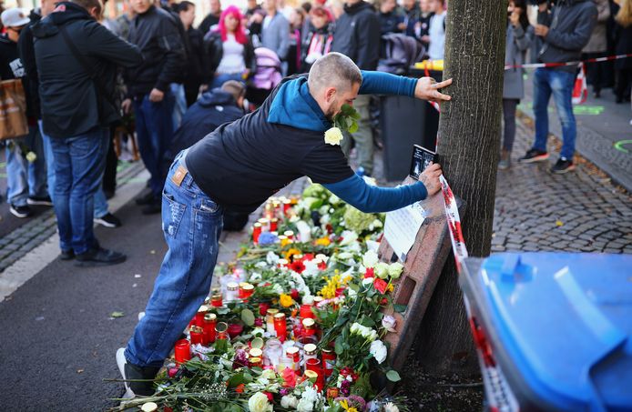 Een man legt bloemen neer op de plek waar de schutter gisteren een inwoner van Halle doodschoot.