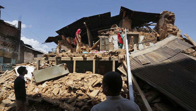 Een Nepalese familie bij hun verwoeste huis in Chautara Beeld ap