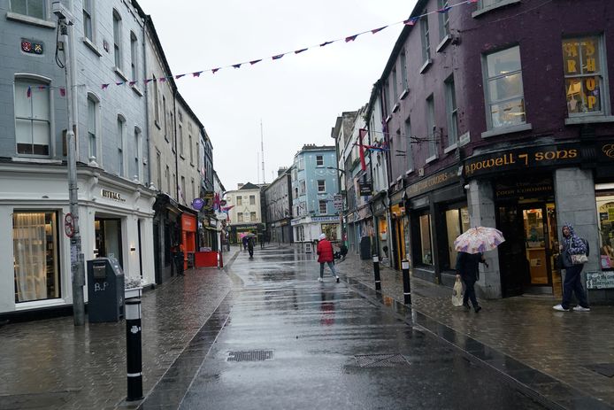Een bijna lege winkelstraat in Galway, aan de westkust. Vanaf morgen gaan alle niet-essentiële winkels dicht, mogen cafés en restaurants alleen nog afhaalgerechten verkopen en moeten de Ieren binnen 5 kilometer van hun huis blijven.