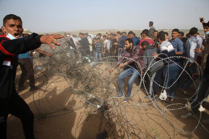 Palestijnen proberen een afscheiding van prikkeldraad weg te halen bij de grens tussen de Gazastrook en Israël.