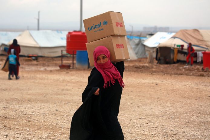 Een Syrische vrouw met een VN-hulppakket, februari 2018. Dit specifieke kamp wordt niet genoemd in de onderzoeken.