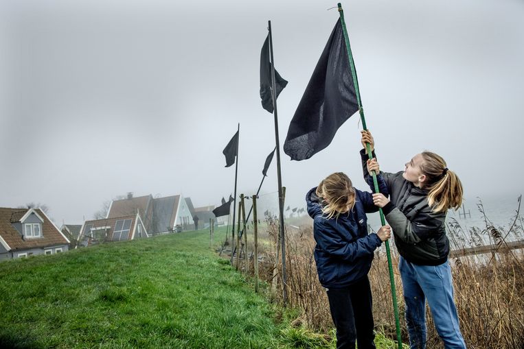 Uit protest tegen dijkverzwaring planten kinderen zwarte vlaggen bij Uitdam. 	 Beeld Jean-Pierre Jans / HH