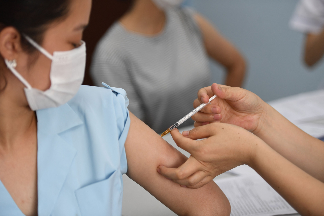 Een Vietnamese vrouw laat zich in Hanoi vaccineren tegen het coronavirus.