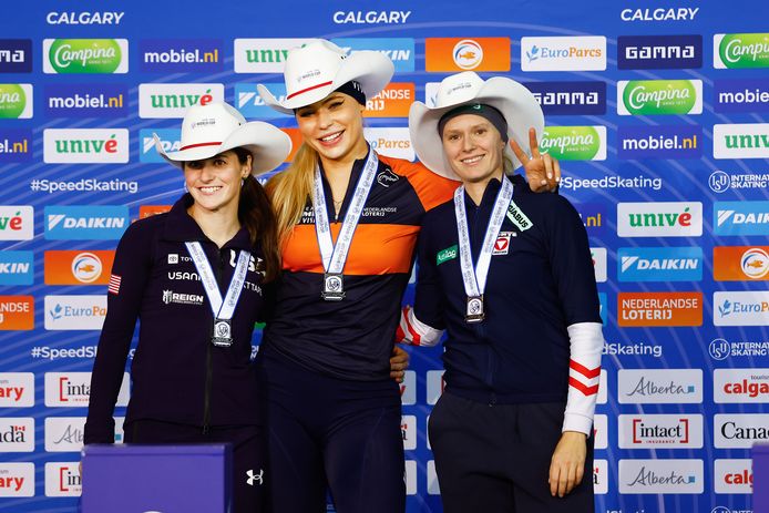Jutta Leerdam na de 1000 meter op het podium tussen Kimi Goetz en Vanessa Herzog.