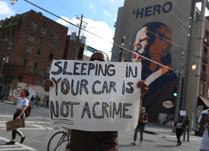 ‘Slapen in je auto is géén misdaad’ staat op een papier in Atlanta Georgia dat een demonstrant omhoog houdt.